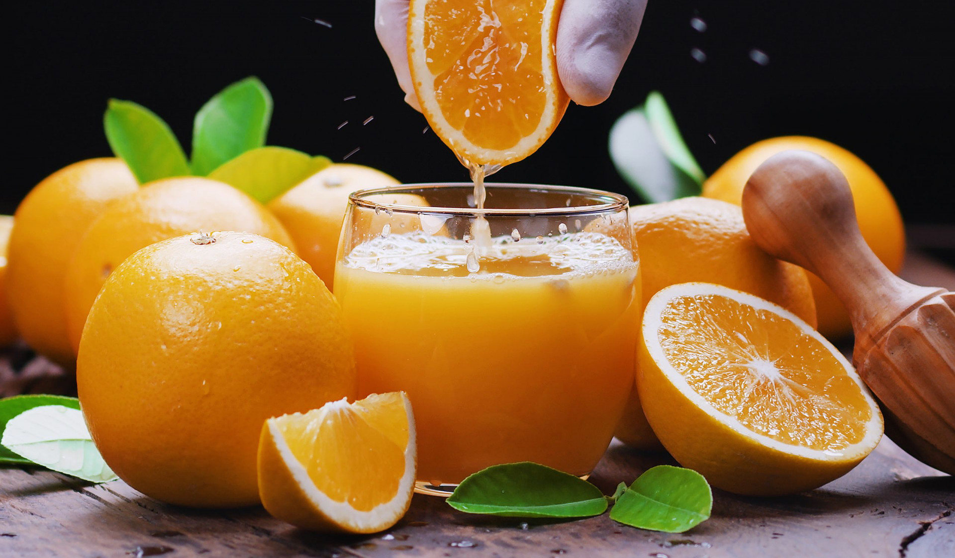 Yellow orange fruits and fresh orange juice. Squeezing out the fresh orange.