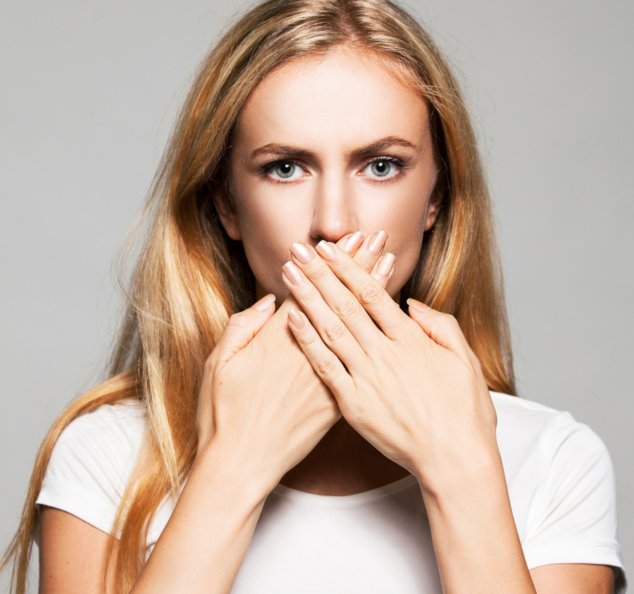 Woman covers her mouth with her hands