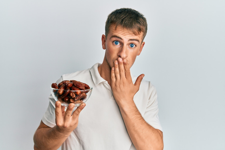 man holding bowl with dates