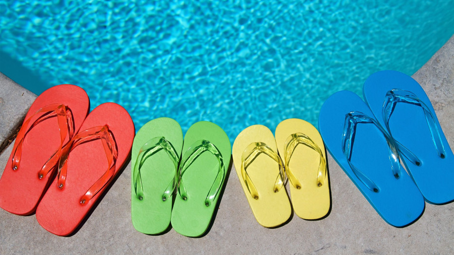 Colored flipflops of a family of four by the swimming pool