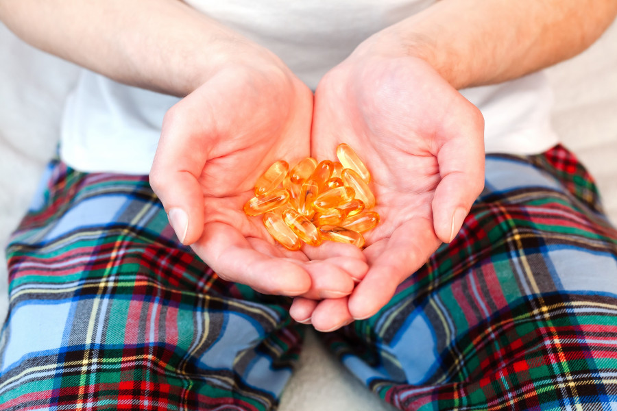 Man Holds A Handful Capsules Of Omega-3 Fatty Acid vitamin d