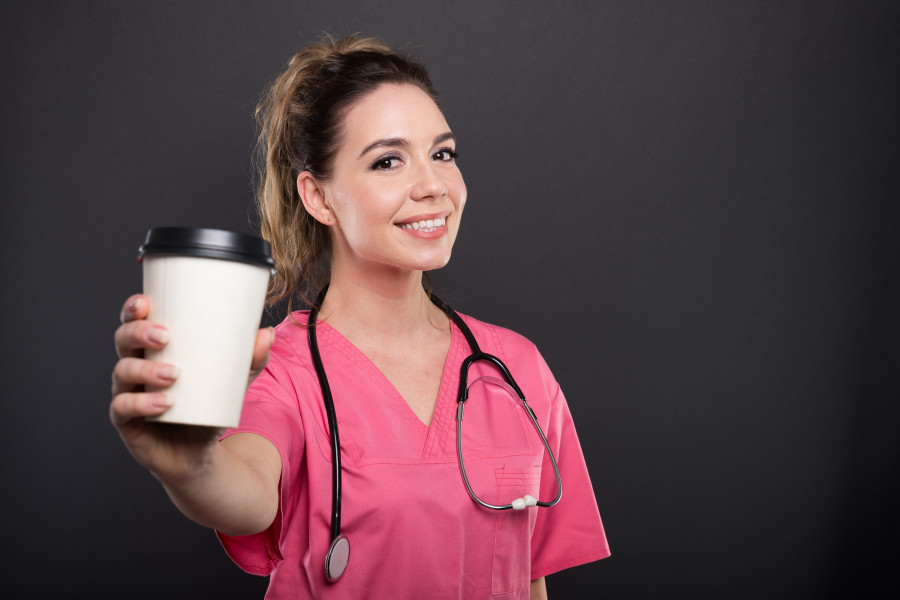 Portrait Of Young Doctor holding cup of Coffee