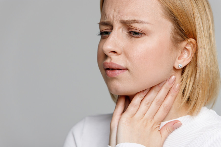 woman suffering from throat problems, holding hands on her lymph nodes