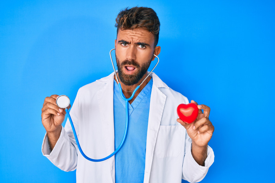 man doctor holding stethoscope and heart