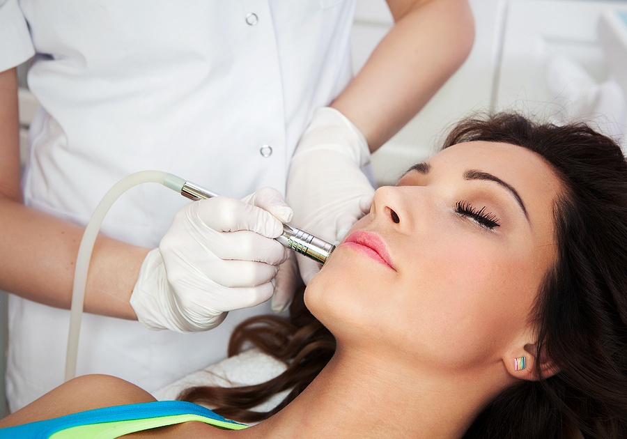 Woman getting laser face treatment in medical spa center
