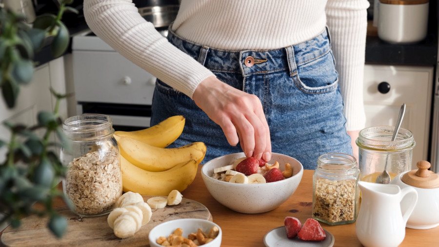 Adding Fruits To Breakfast Oatmeal Porridge Bowl