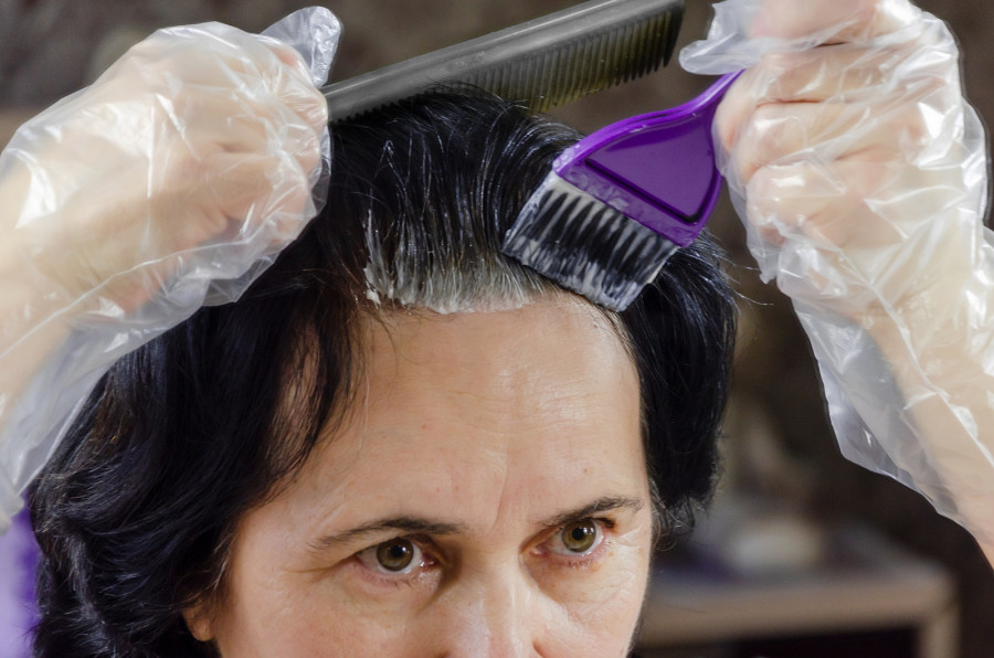 Woman Dying Her Hair In Front Of Mirror