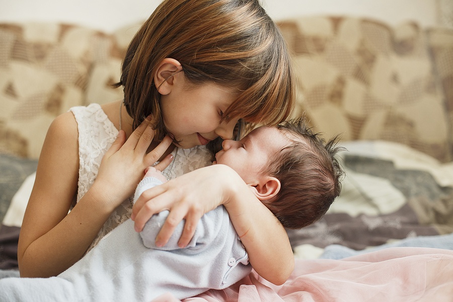 Little Sister Hugging Her Newborn Brother