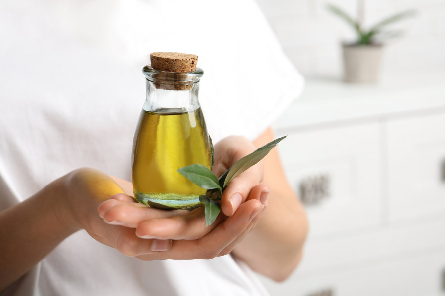 Young Woman Holding Bottle Of Fresh Olive Oil