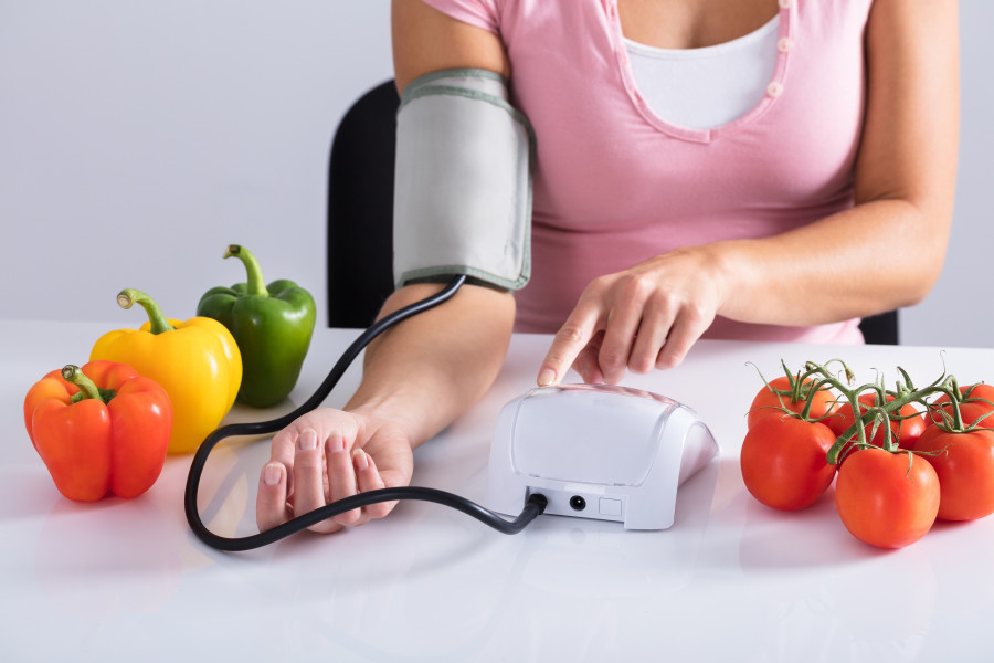 Woman Checking Blood Pressure On Table With Vegetables