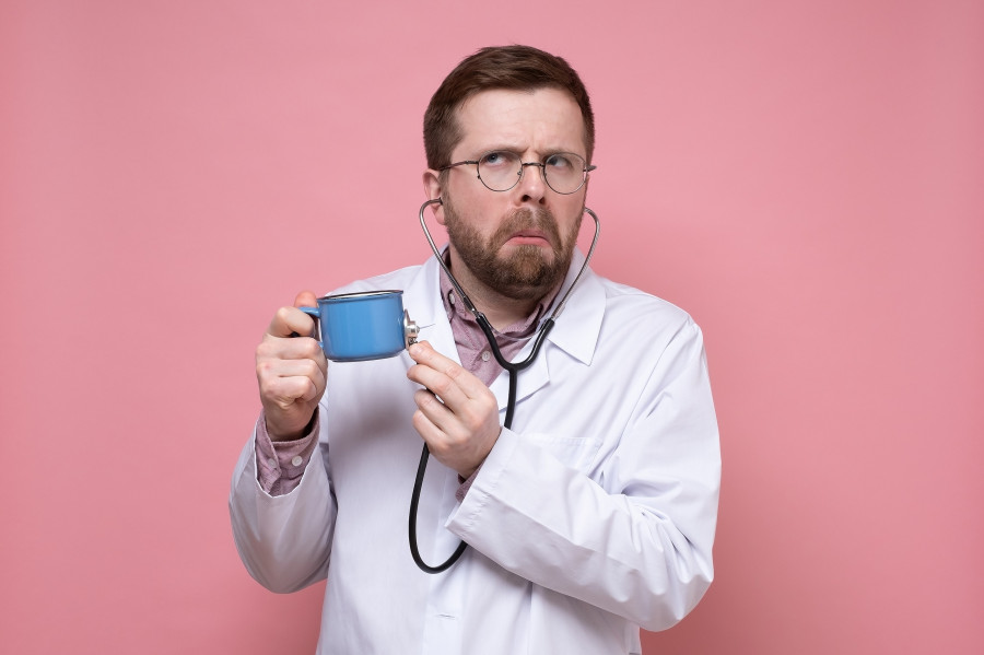 Perplexed Doctor Holds A Mug Of Coffee