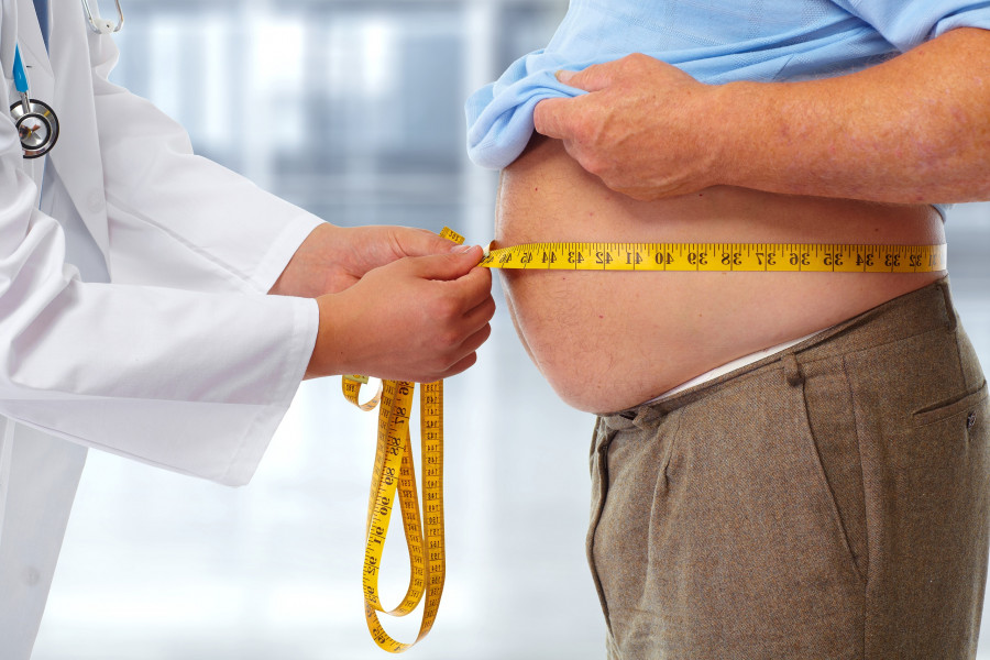 Doctor measuring man waist body fat. Obesity and weight loss