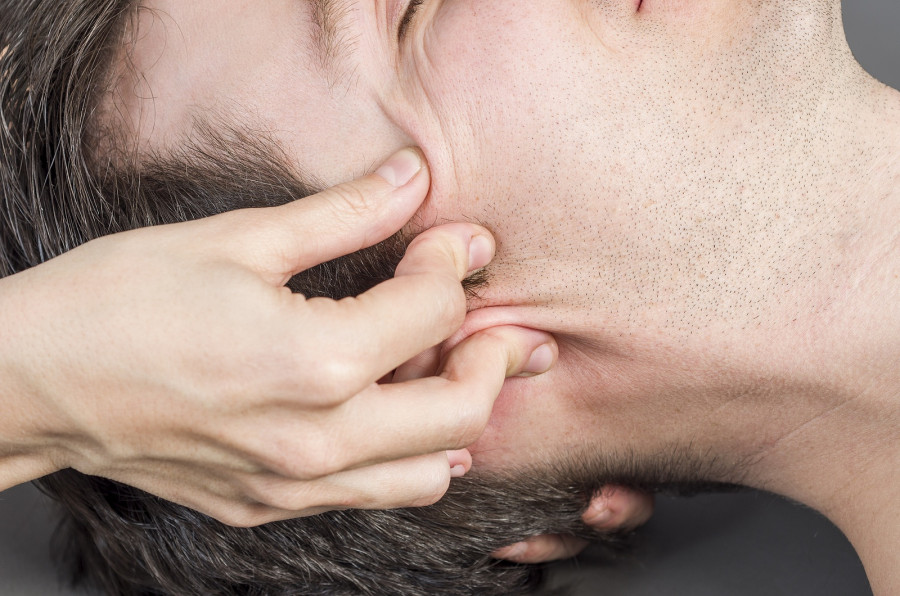 Physiotherapist is activating trigeminal nerve to male patient