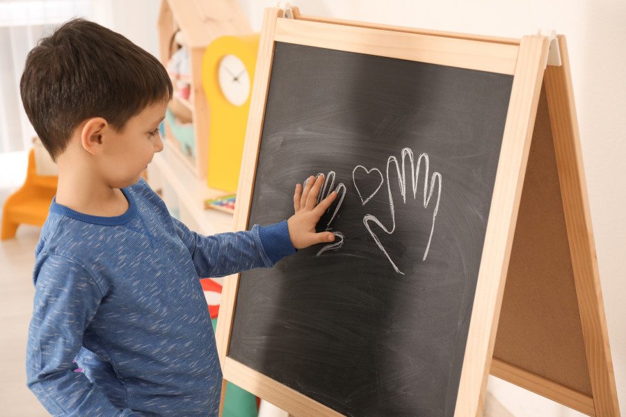 boy putting his palm on drawing at child psychologist's office