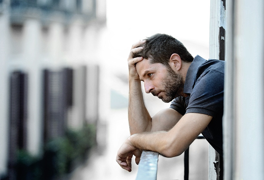 Young Man At Balcony In Depression Suffering Emotional Crisis