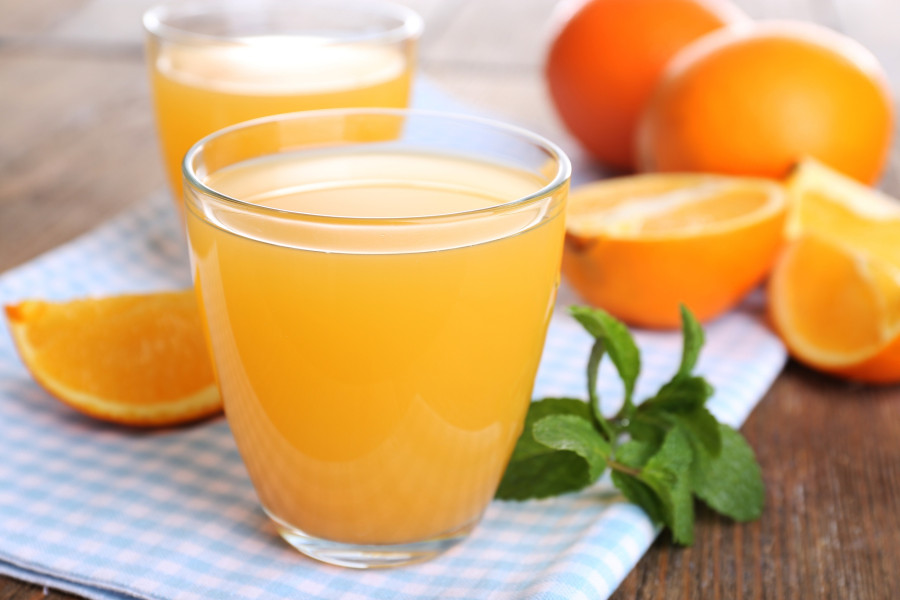 Glasses of orange juice with oranges