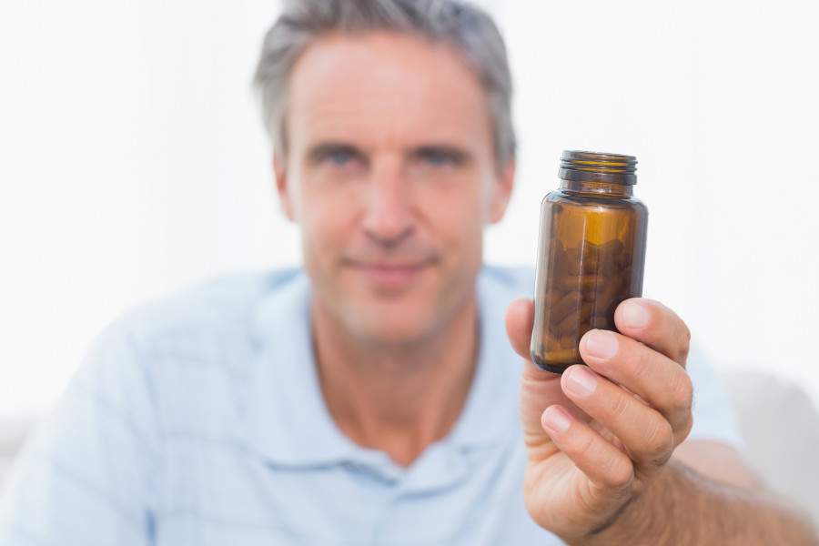 Man showing bottle of pills