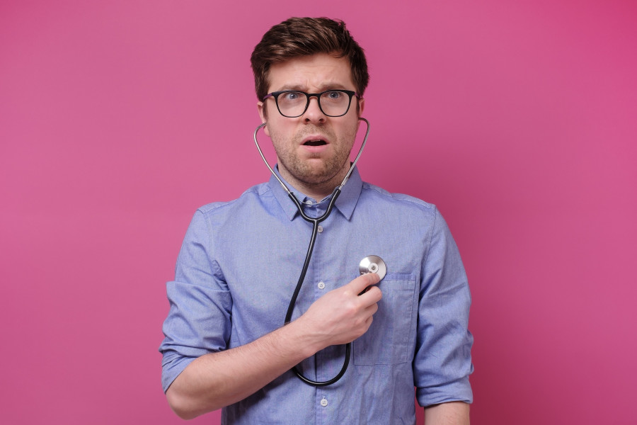 Worried Man Listening To His Heart With Stethoscope
