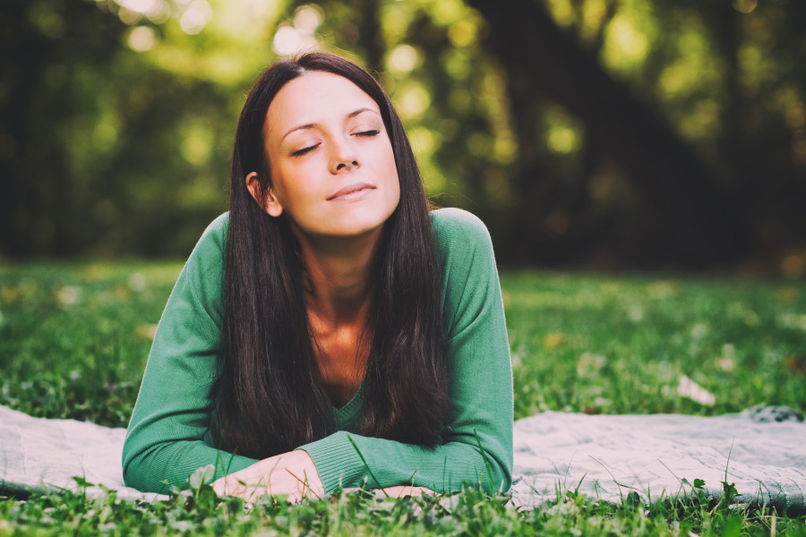 woman lying down in nature and thinking about something
