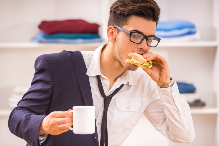 Man eating his breakfast while hurrying to work