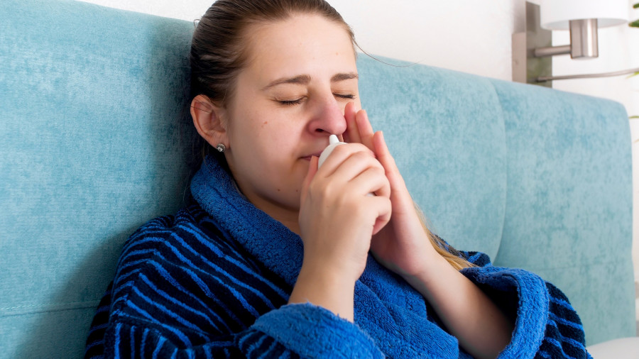 Woman Feeling Unwell Using Nasal Spray