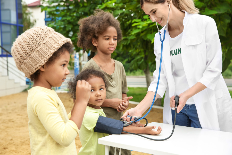 Volunteer doctor measuring blood pressure of poor African child