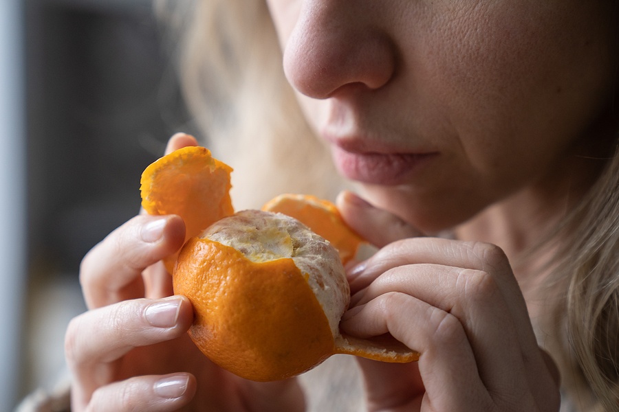 Woman Trying To Sense Smell Of Fresh Tangerine Orange