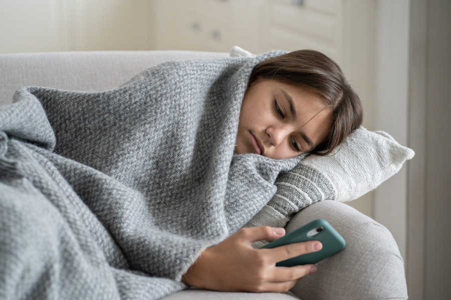 Girl Wrapped In Plaid Lying On Sofa