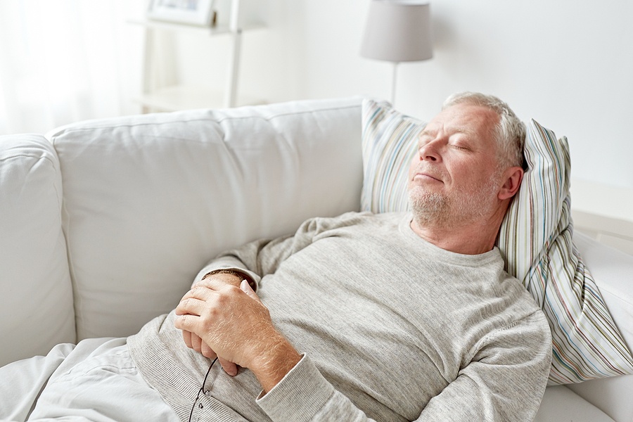 senior man sleeping on sofa at home