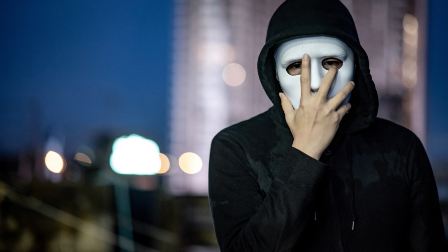 Mystery Hoodie Man In White Mask. Standing On Rooftop Of Abandon