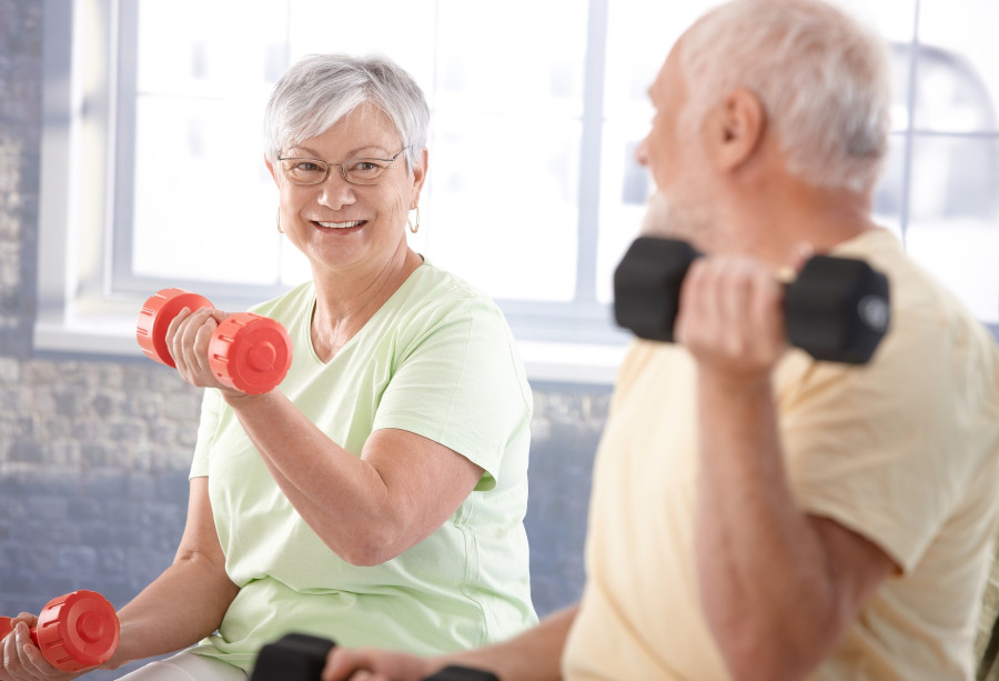 Vital senior couple exercising in the gym