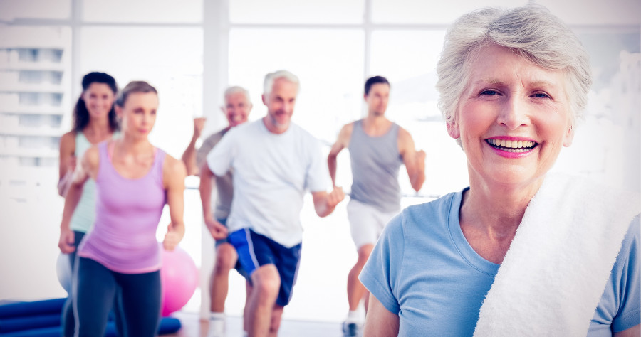 senior woman with people exercising in gym