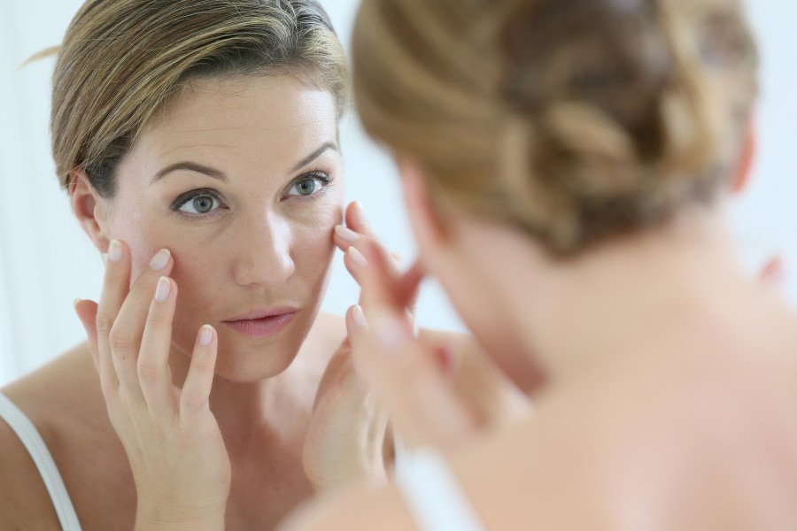 Middle-aged woman applying anti-aging cream